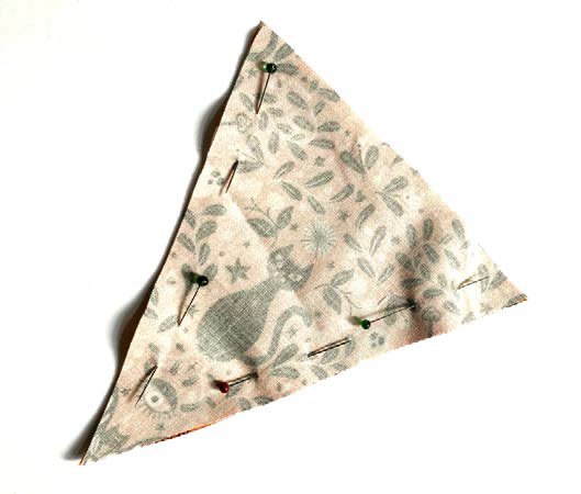 Fabric triangle pieces pinned together for Halloween bunting